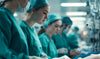 A team of surgeons in green scrubs collaborates in a medical setting, focused on patient care and surgical procedures.