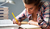 A woman studying nursing with a pencil and book, taking notes and using a study guide